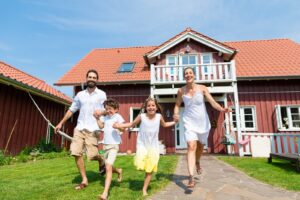 Family running across the lawn in front of a vacation home