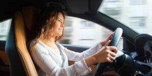 Young woman driving a car with both hands on the wheel